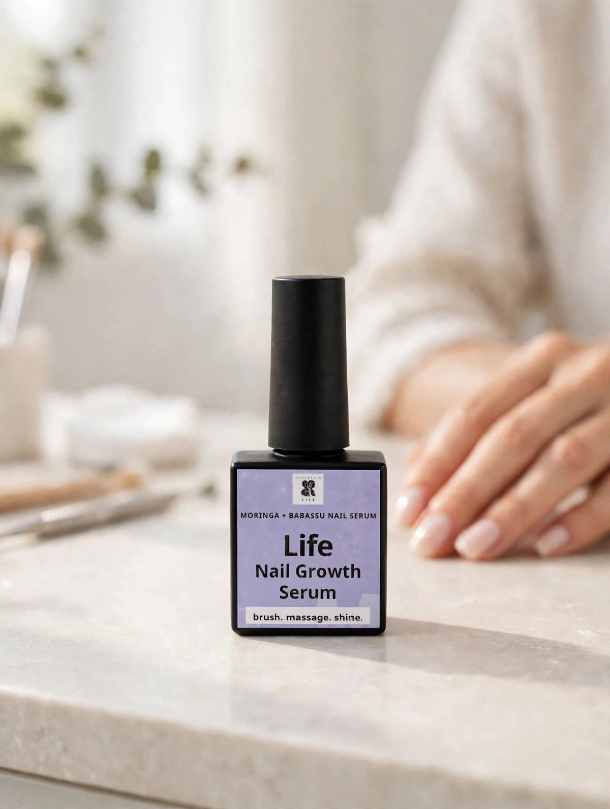 Life Nail Growth Serum bottle on a bright manicure table beside a hand with neat nails